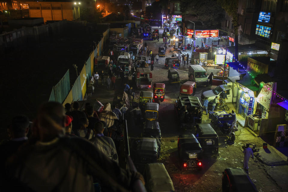 In this Nov. 24, 2019 photo, tuk-tuk drivers make their way on a crowded street at a slum area in Cairo, Egypt. Motorized rickshaws known as tuk-tuks have ruled the streets of Cairo’s slums for the past two decades hauling millions of Egyptians home every day. Now the government is taking its most ambitious stand yet against the polluting three-wheeled vehicles: to modernize the neglected transport system, it plans to replace tuk-tuks with clean-running minivans. (AP Photo/Nariman El-Mofty)