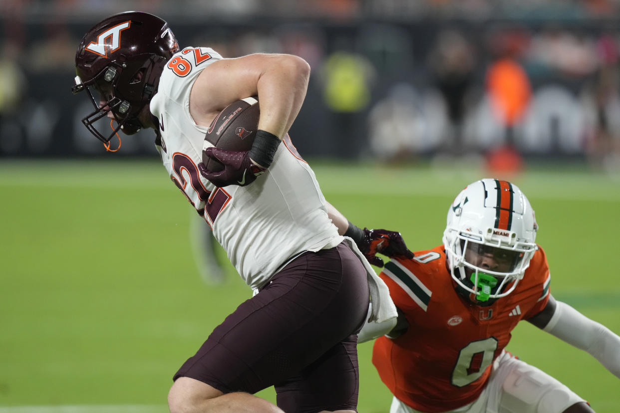 Miami defensive back Mishael Powell (0) grabs Virginia Tech tight end Benji Gosnell (82) during the first half of an NCAA college football game, Friday, Sept. 27, 2024, in Miami Gardens, Fla. (AP Photo/Marta Lavandier)