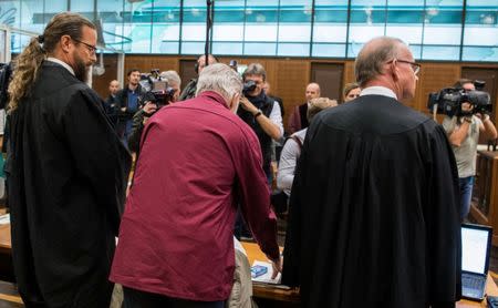 Defendant Swiss man Daniel M., accused of spying on a German tax authority to find out how it obtained details of secret Swiss bank accounts set up by Germans to avoid tax, stands next to his lawyers Hannes Linke (R) and Anwalt Robert Kain (L) before the start of his trial on espionage charges, in the Higher Regional Court in Frankfurt am Main, Germany October 18, 2017. REUTERS Andreas Arnold/Pool