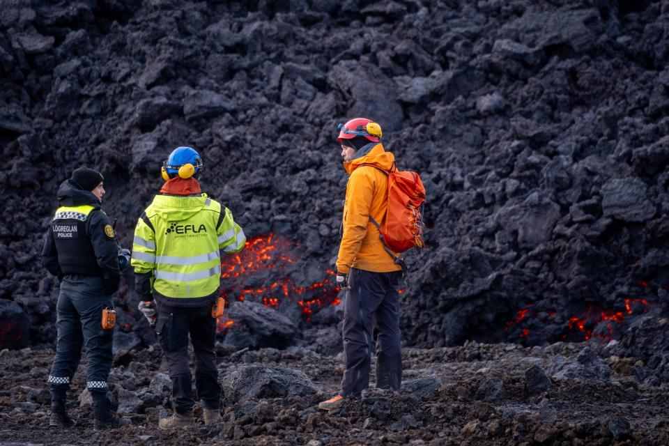 A police officer and engineer stand next to the lava field of a volcanic eruption in Iceland (EPA)