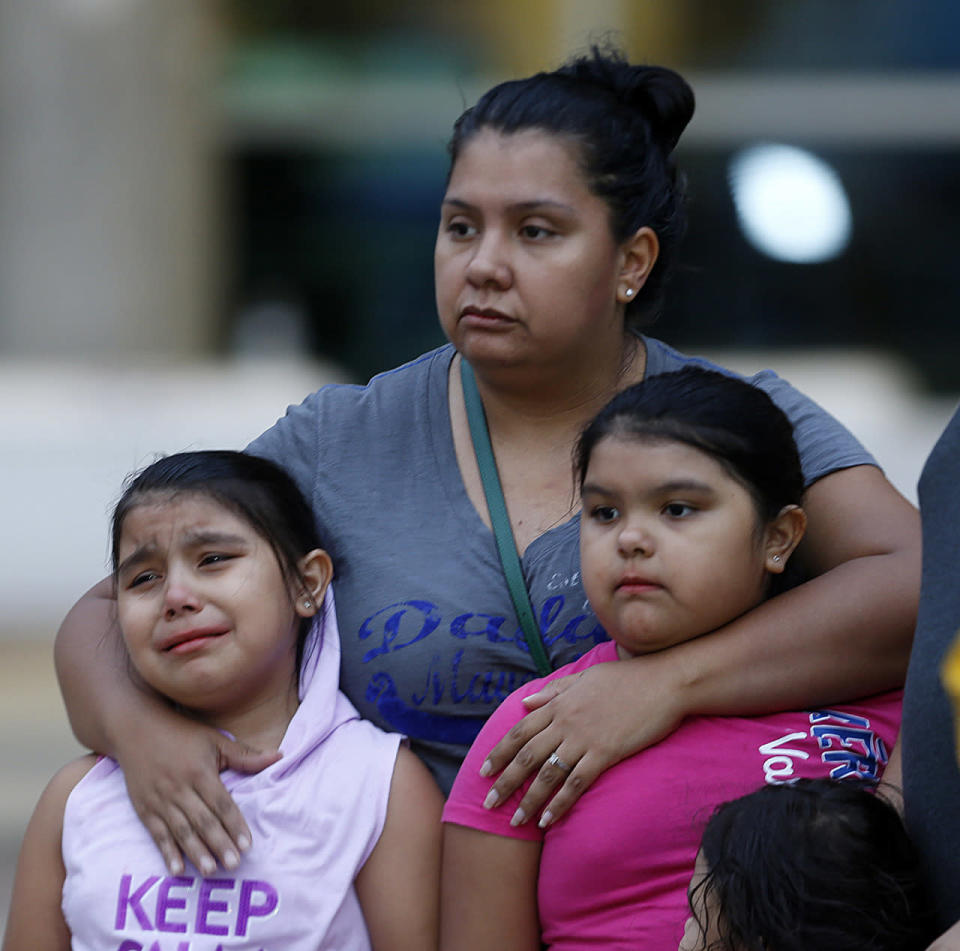 Crystal Delgado comforts her children Brielle, 8, and Dasani, 10, while at a makeshift memorial