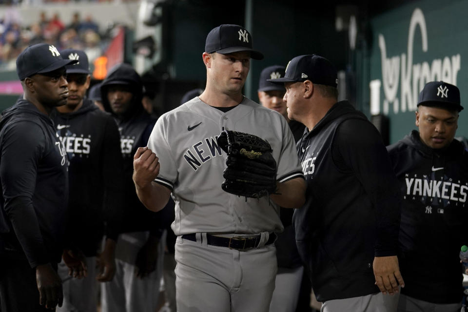 New York Yankees starting pitcher Gerrit Cole, center, is greeted in the dugout after being pulled in the seventh inning of the team's baseball game against the Texas Rangers, Thursday, April 27, 2023, in Arlington, Texas. (AP Photo/Tony Gutierrez)