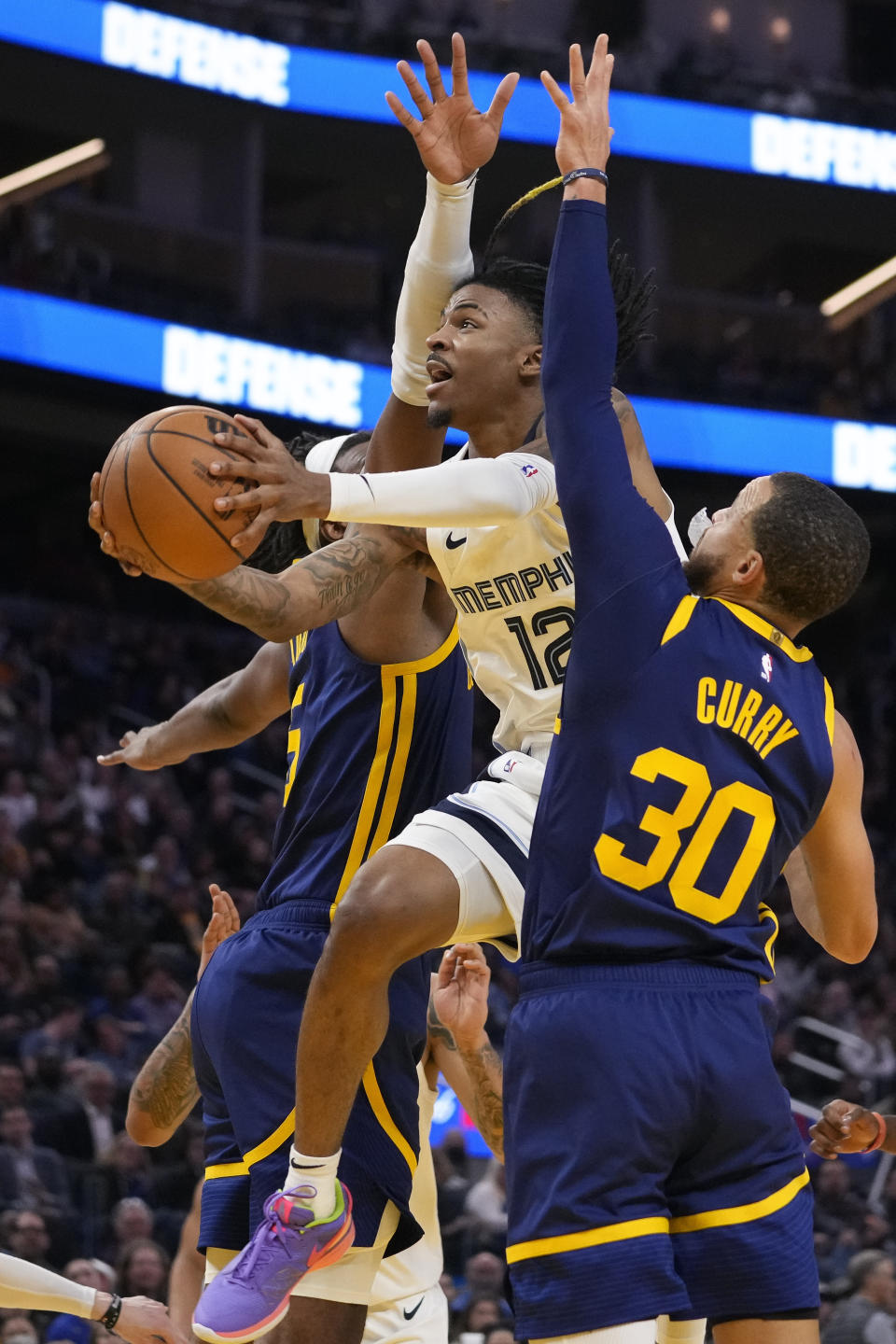 Memphis Grizzlies guard Ja Morant, middle, shoots between Golden State Warriors center Kevon Looney, left, and guard Stephen Curry during the first half of an NBA basketball game in San Francisco, Wednesday, Jan. 25, 2023. (AP Photo/Godofredo A. Vásquez)