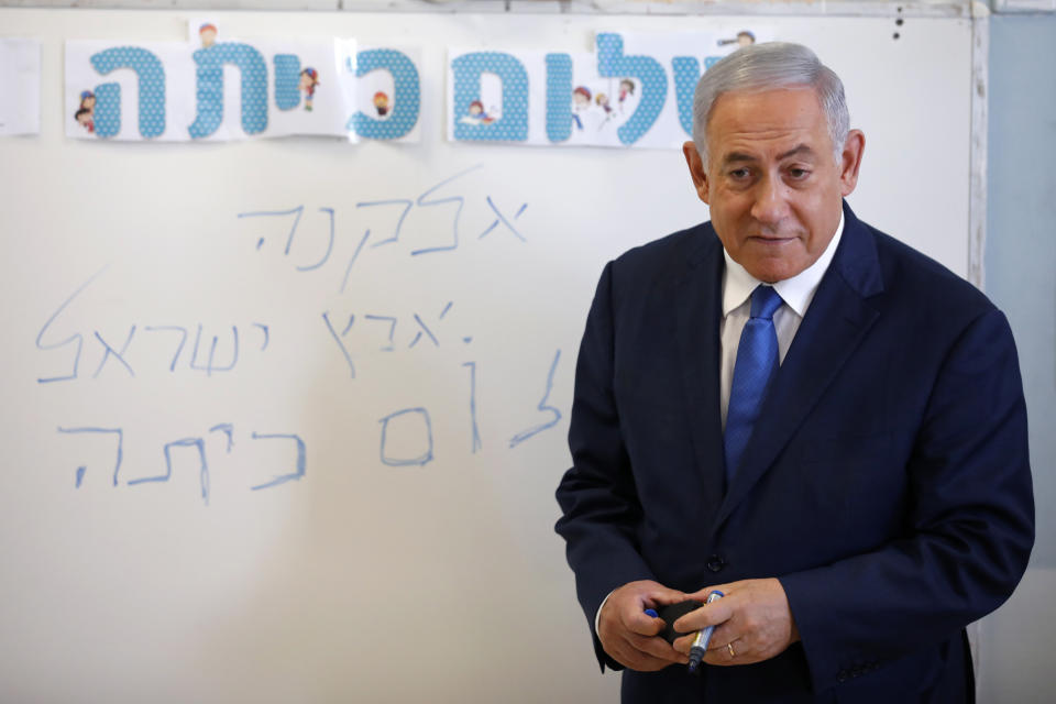 Israeli Prime Minister Benjamin Netanyahu speaks to students during a ceremony opening the new school year, Sunday, Sept. 1, 2019, in the West Bank Israeli settlement of Elkana. Speaking Sunday at the ceremony, Netanyahu reaffirmed his pledge to impose Israeli sovereignty on West Bank settlements. The writing in Hebrew reads, " Elkana, Land of Israel, Hello Class." (Amir Cohen/Pool Photo via AP)