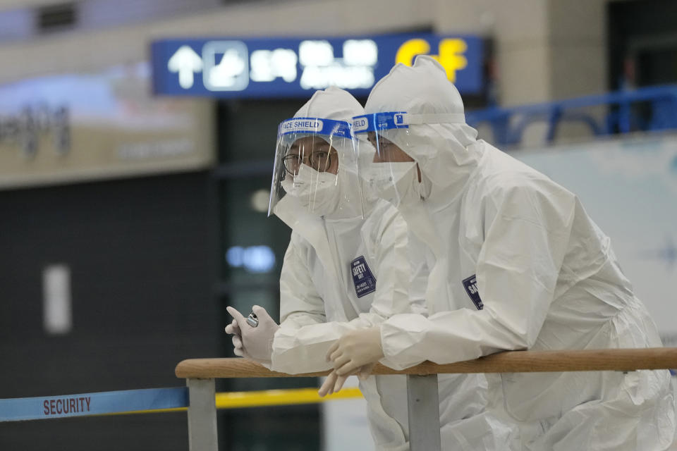 Quarantine officers wait to guide travelers at the arrival hall of the Incheon International Airport In Incheon, South Korea, Wednesday, Dec. 1, 2021. South Korea's daily jump in coronavirus infections exceeded 5,000 for the first time since the start of the pandemic, as a delta-driven surge also pushed hospitalizations and deaths to record highs. (AP Photo/Ahn Young-joon)