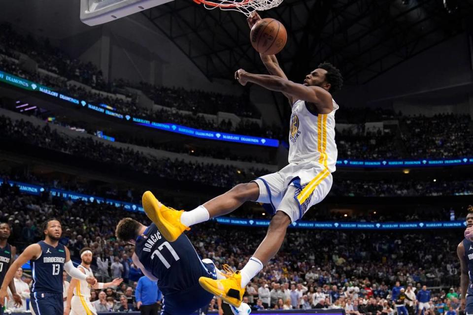 Golden State Warriors forward Andrew Wiggins (22) dunks the ball over Dallas Mavericks guard Luka Doncic (77) during the second half of Game 3 of the NBA basketball playoffs Western Conference finals, Sunday, May 22, 2022, in Dallas. (AP Photo/Tony Gutierrez)