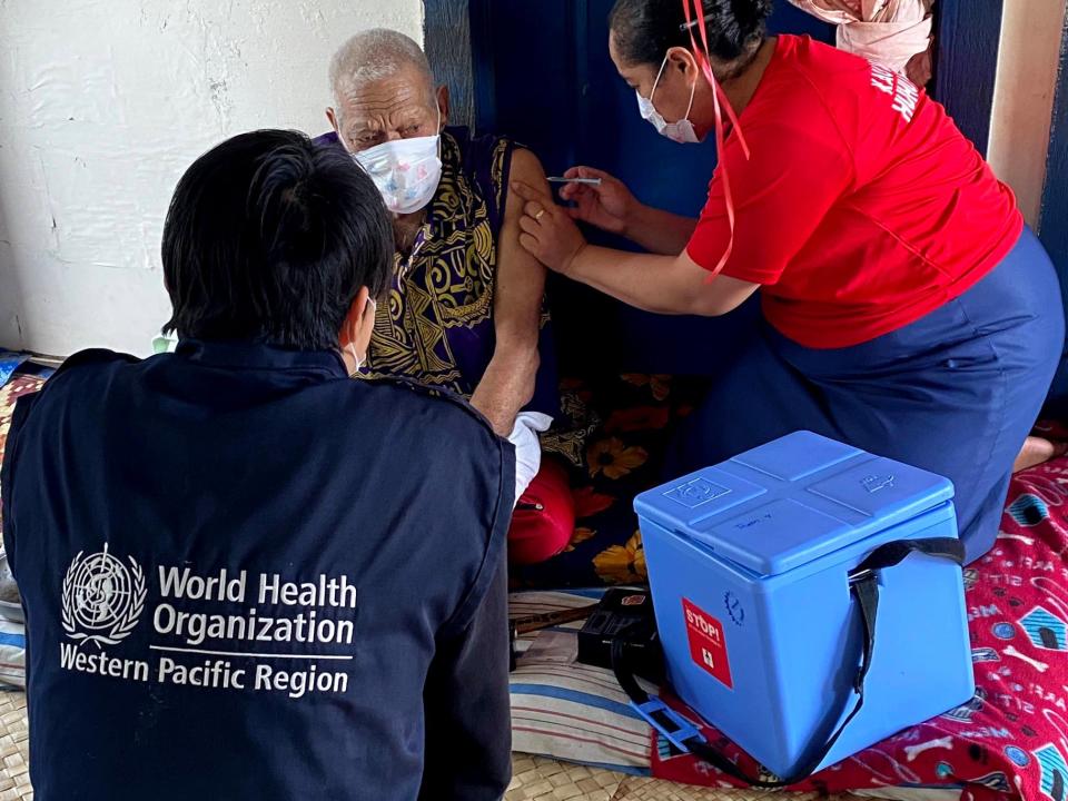 World Health Organisation staff vaccinate a resident in Tonga.