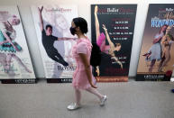 Ballet student Micah Sparrow walks past dance performance posters at the Texas Ballet Theatre, Wednesday, Oct. 7, 2020, in Fort Worth, Texas. For many, it's not Christmas without the dance of Clara, Uncle Drosselmeyer, the Sugar Plum Fairy, the Mouse King and, of course, the Nutcracker Prince. But this year the coronavirus pandemic has canceled performances of “The Nutcracker” around the U.S. and Canada, eliminating a major and reliable source of revenue for dance companies already reeling financially following the essential shutdown of their industry. (AP Photo/LM Otero)