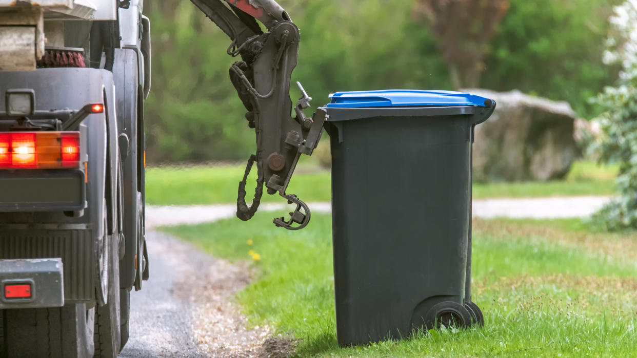 Garbage disposal truck lifting a waste bin