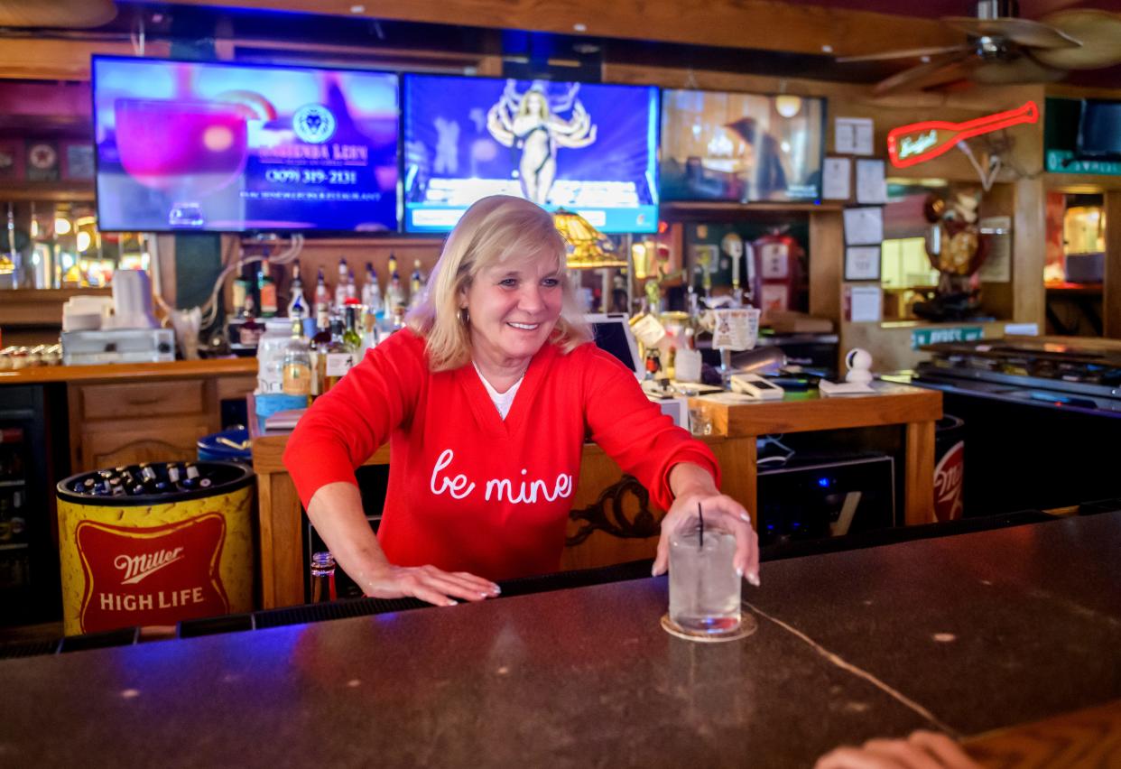 Kirstie Doerr, owner of the Owl's Nest, serves up a drink to one of her regular customers at the popular West Peoria bar and grill.