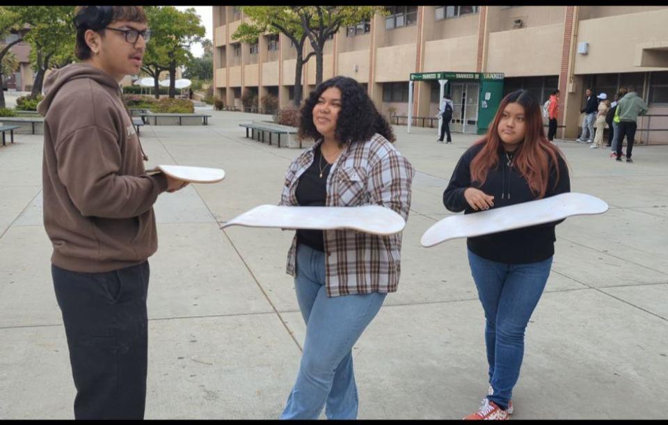 Alexander Hamilton High School students Dylan Songco, Rubi Aparicio and Wendy Lopez hold their primed skateboard decks. The boards will be decorated with their unique art as part of the Tyre Nichols Project.