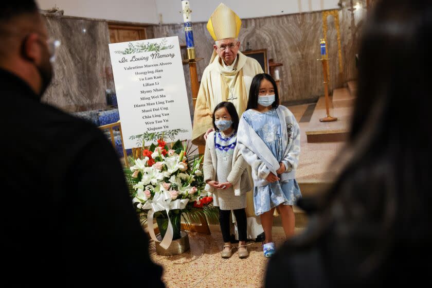 Archbishop Jose H. Gomez takes a picture with children following a mass in memory of the Monterey Park shooting victims