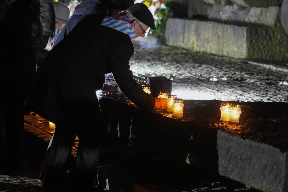 A Holocaust survivor places a llit candle at the monument at the Birkenau Nazi death camp during a ceremony in Oswiecim, Poland, Saturday, Jan. 27, 2024. Survivors of Nazi death camps marked the 79th anniversary of the liberation of the Auschwitz-Birkenau camp during World War II in a ceremony in southern Poland.(AP Photo/Czarek Sokolowski)