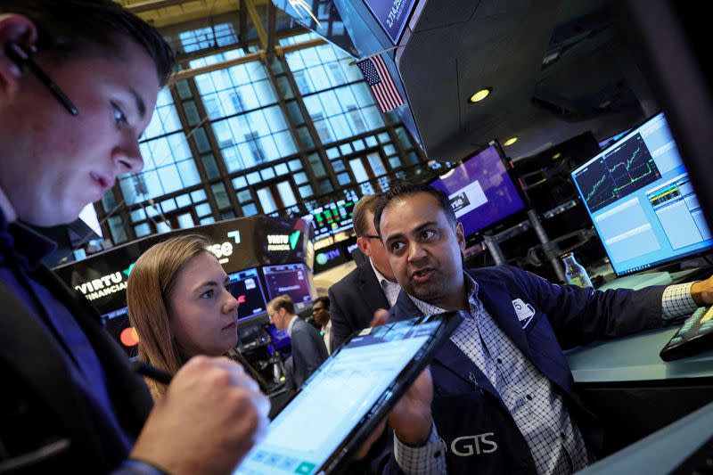 FILE PHOTO: Traders work on the floor of the NYSE in New York