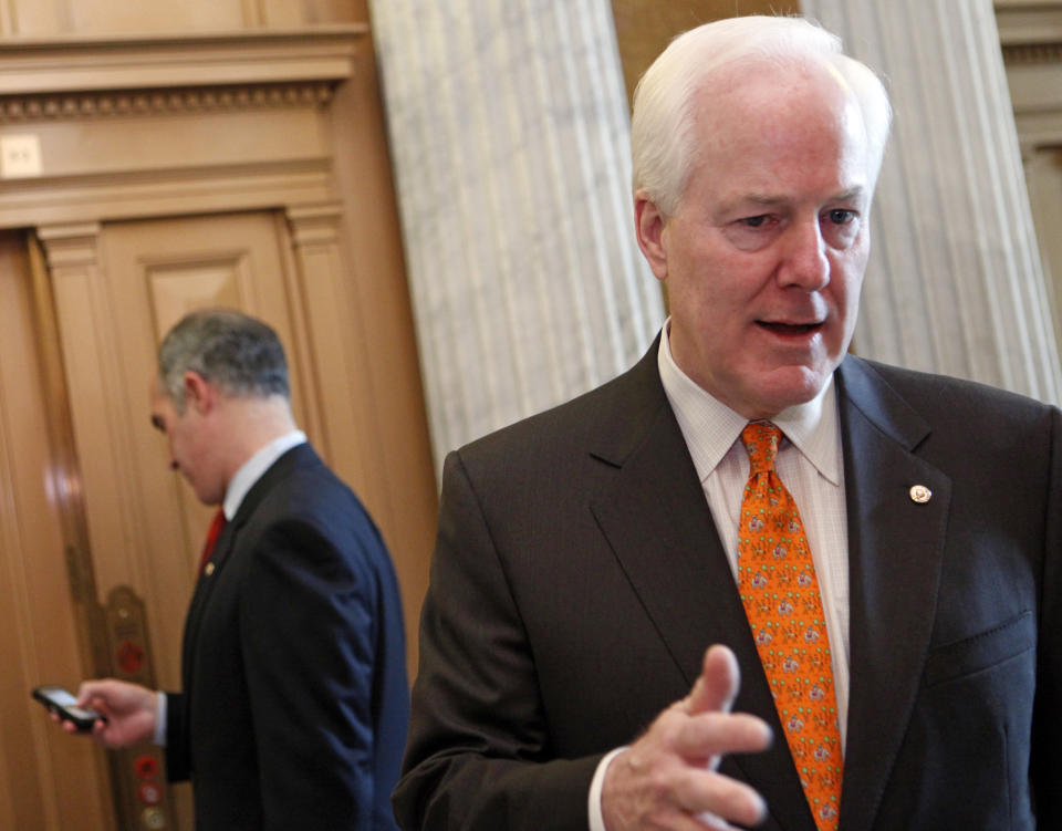 Sen. John Cornyn, R-Texas, right, talks with reporters as Sen. Robert Casey, Jr., D-Pa., rear, checks his phone following a series of votes on Capitol Hill, Tuesday, Dec. 22, 2009, in Washington. (AP Photo/Haraz N. Ghanbari)