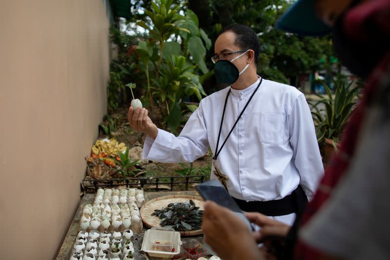 The Wider Image: Hazmat suits and holy water: two priests bring faith to Philippines lockdown