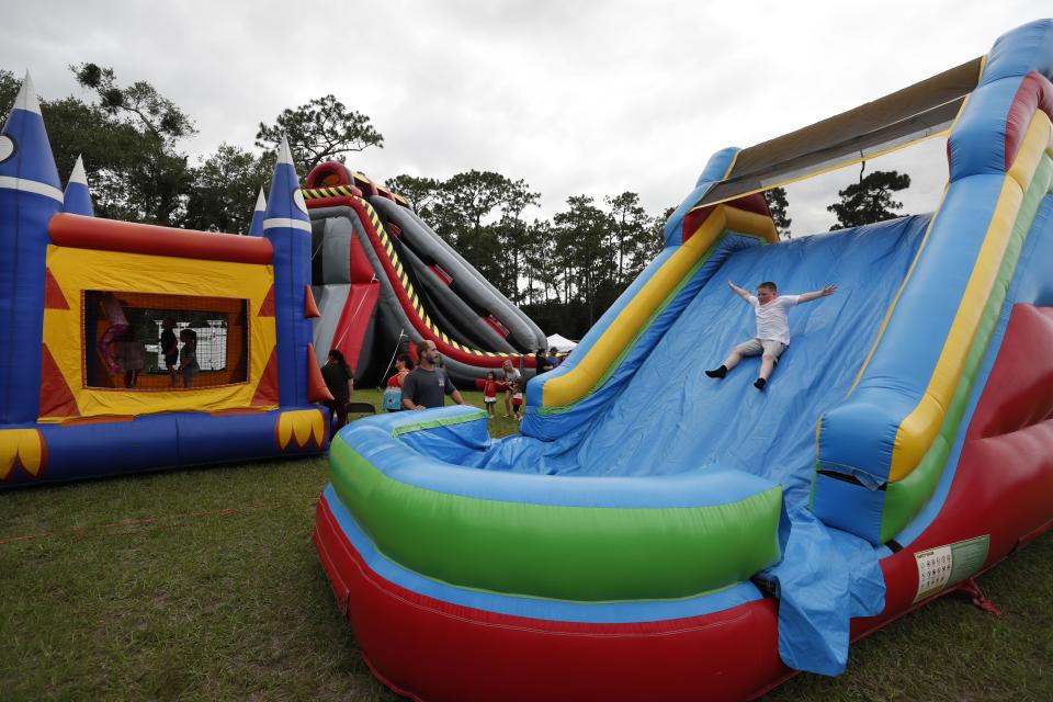 A boy slides down an inflatable amusement at Valentine Park in Orange City on Saturday. Because of safety and insurance concerns, Volusia County has banned the use of bounce houses and similar inflatables from county properties. [News-Journal/Nigel Cook]