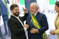 President Luiz Inacio Lula da Silva, right, poses for a picture with Chile's President Gabriel Boric after he was sworn in as new president at the Planalto Palace in Brasilia, Brazil, Sunday, Jan. 1, 2023. (AP Photo/Eraldo Peres)