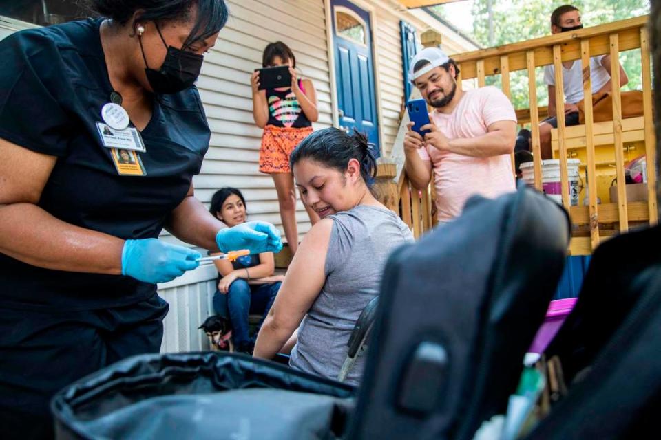 Dr. Nerissa Price administers a COVID-19 vaccine to Yeni Umanzor, 21, as volunteer canvassers went door to door offering vaccines at a Raleigh mobile home park in Raleigh on July 23, 2021. Using census tract data to identify low vaccination areas in Wake County, outreach teams worked to increase vaccine rates in communities with low vaccination rates.