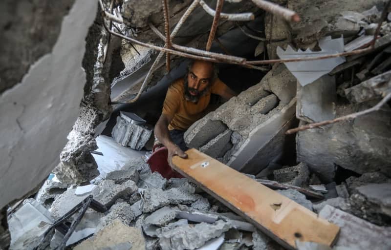 A Palestinian man searches inside a destroyed home as he returns after the Israeli army withdrew from the Austrian neighbourhood during the violent battles between Israel and Hamas. Abed Rahim Khatib/dpa