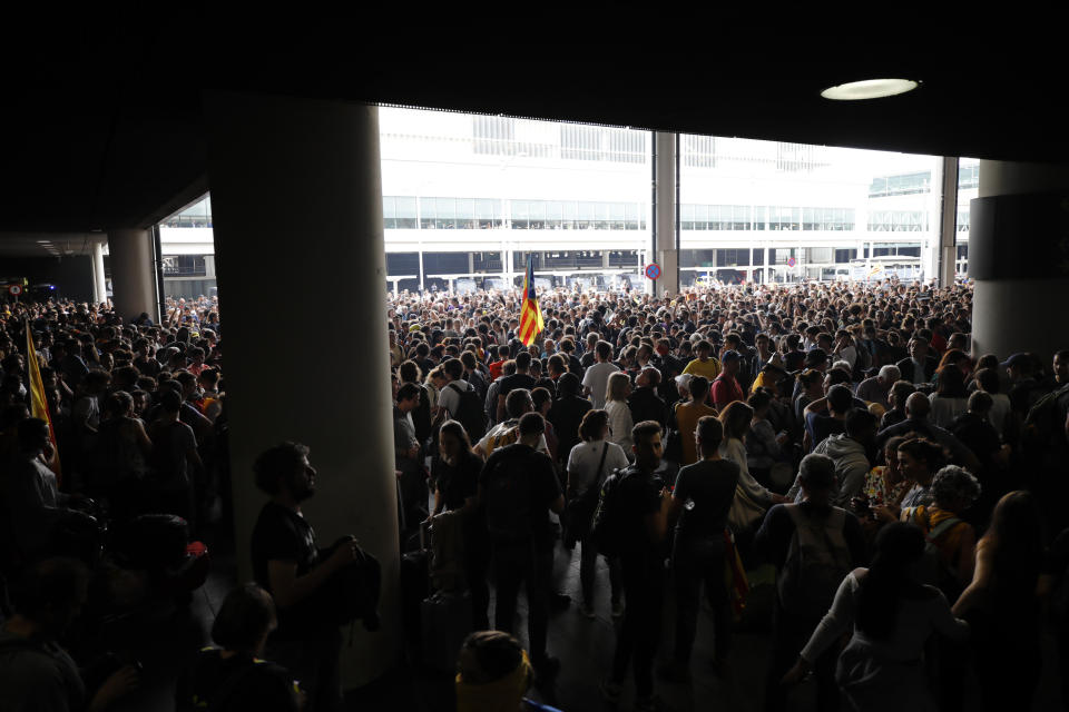 An Estelada pro-independence flag is waved among protestors at El Prat airport in Barcelona, Spain, Monday, Oct. 14, 2019. Spain's Supreme Court on Monday convicted 12 former Catalan politicians and activists for their roles in a secession bid in 2017, a ruling that immediately inflamed independence supporters in the wealthy northeastern region. (AP Photo/Emilio Morenatti)