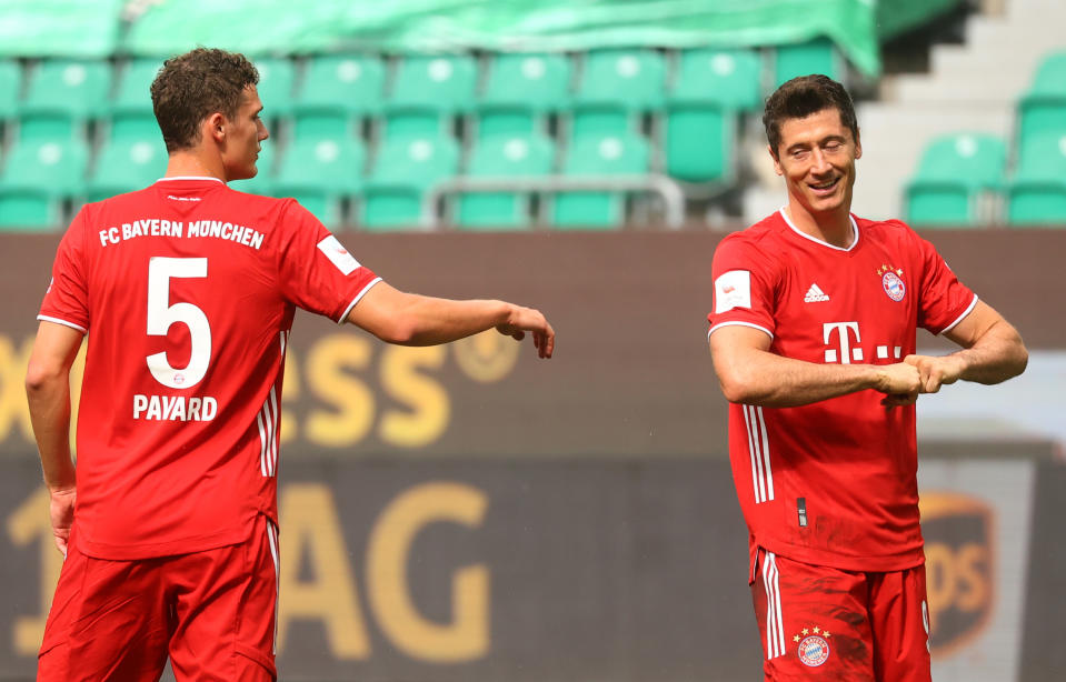 Bayern Munich's Polish forward Robert Lewandowski (R) celebrates scoring the third goal for his team with Bayern Munich's French defender Benjamin Pavard during the German first division Bundesliga football match VfL Wolfsburg v Bayern Munich on June 27, 2020 in Wolfsburg, northern Germany. (Photo by KAI PFAFFENBACH / POOL / AFP) / DFL REGULATIONS PROHIBIT ANY USE OF PHOTOGRAPHS AS IMAGE SEQUENCES AND/OR QUASI-VIDEO (Photo by KAI PFAFFENBACH/POOL/AFP via Getty Images)