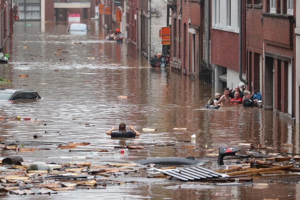 A woman is trying to move in a flooded street following heavy rains in Liege, Belgium on July 15, 2021.