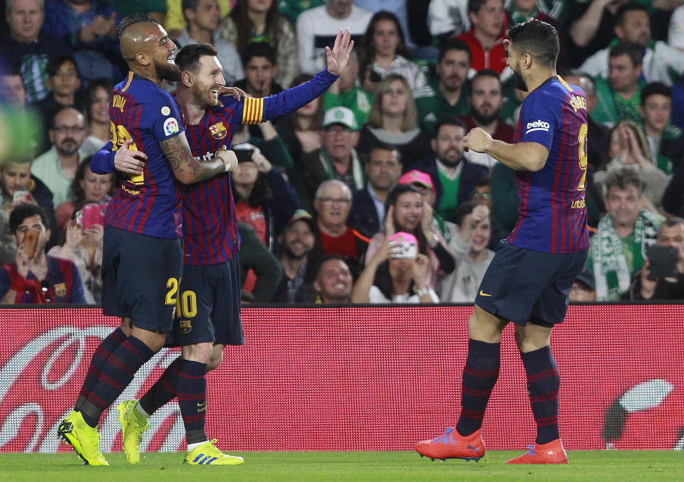 Barcelona's Messi, second left, celebrates after scoring with teammate Aleix Vidal, left, and Suarez during La Liga soccer match between Betis and Barcelona at the Benito Villamarin stadium in Seville, Spain, Sunday, March 17, 2019. (AP Photo/Miguel Morenatti)