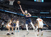 Denver Nuggets center Nikola Jokic, center, drives to the basket between Atlanta Hawks forward John Collins, left, and center Clint Capela (15) in the second half of an NBA basketball game Saturday, Feb. 4, 2023, in Denver. (AP Photo/David Zalubowski)