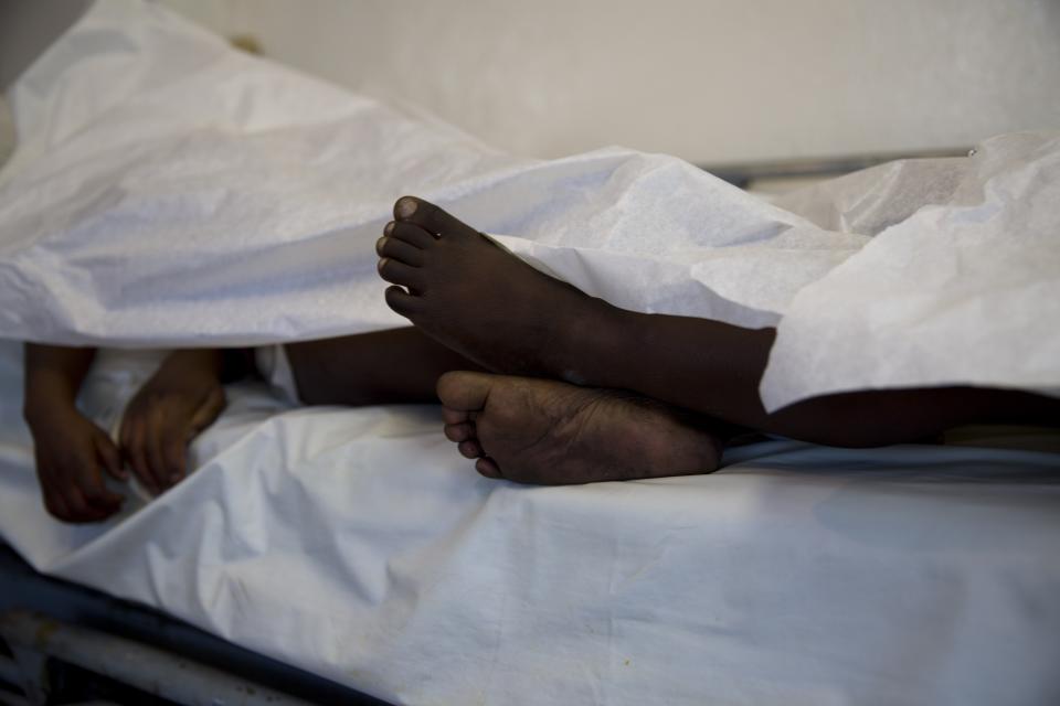 The feet and hands of children, who died in a fire at the Orphanage of the Church of Bible Understanding, are seen from under a sheet as they lie on a bed at Baptiste Mission Hospital in Kenscoff, on the outskirts of Port-au-Prince, Haiti, Friday, Feb. 14, 2020. A fire swept through a Haitian children’s home run by a Pennsylvania-based nonprofit group, killing 13 children, health care workers said Friday. (AP Photo/Dieu Nalio Chery)