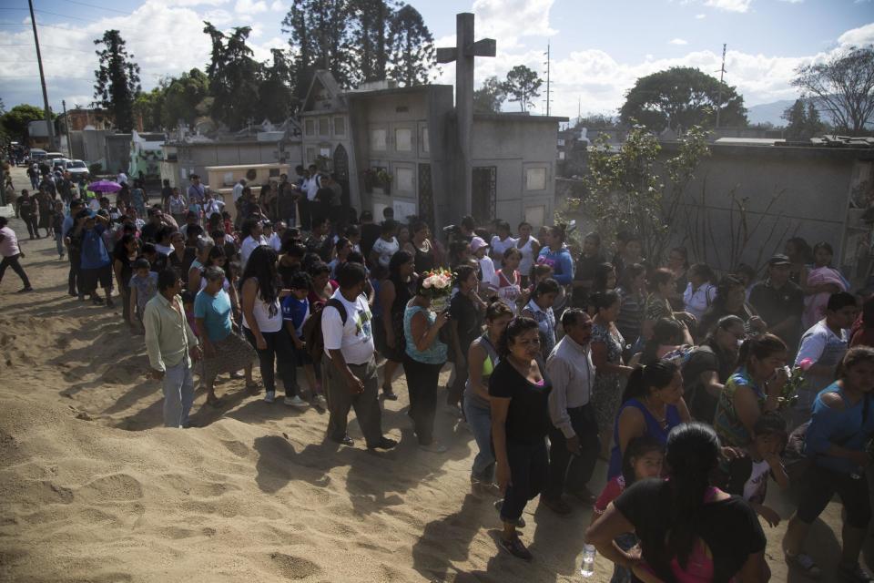 People accompany the burial of 14-year-old Madelyn Patricia Hernandez Hernandez, a girl who died in a fire at the Virgin of the Assumption Safe Home, at the Guatemala City's cemetery, Friday, March 10, 2017. Families began burying some of the 36 girls killed in a fire at an overcrowded government-run youth shelter in Guatemala as authorities worked to determine exactly what happened. (AP Photo/Luis Soto)