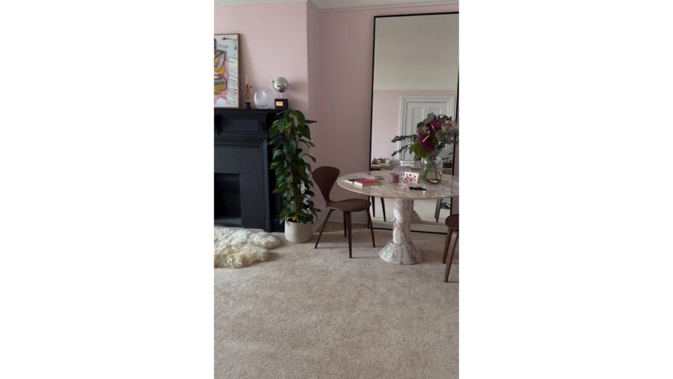 A marble round table in the corner in front of a mirror