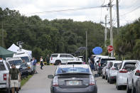 Vehicles from members of the media and curious passersby line a road outside the entrance of the Carlton Reserve during a search for Brian Laundrie, Tuesday, Sept. 21, 2021, in Venice, Fla. Laundrie is a person of interest in the disappearance of his girlfriend, Gabrielle "Gabby" Petito. (AP Photo/Phelan M. Ebenhack)