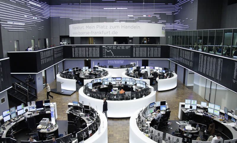 Traders are pictured at their desks in front of the DAX board at the Frankfurt stock exchange October 16, 2014. REUTERS/Remote/Stringer