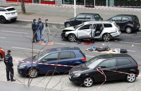 Police inspect the scene of a damaged Volkswagen car in the Bismarckstrasse in Berlin, Germany March 15, 2016. REUTERS/Fabrizio Bensch