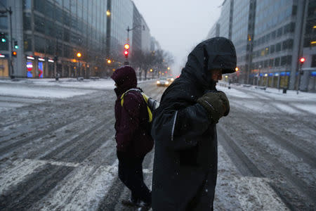 Pedestrians cross a steet after a winter storm arrived in Washington, January 22, 2016. REUTERS/Jonathan Ernst