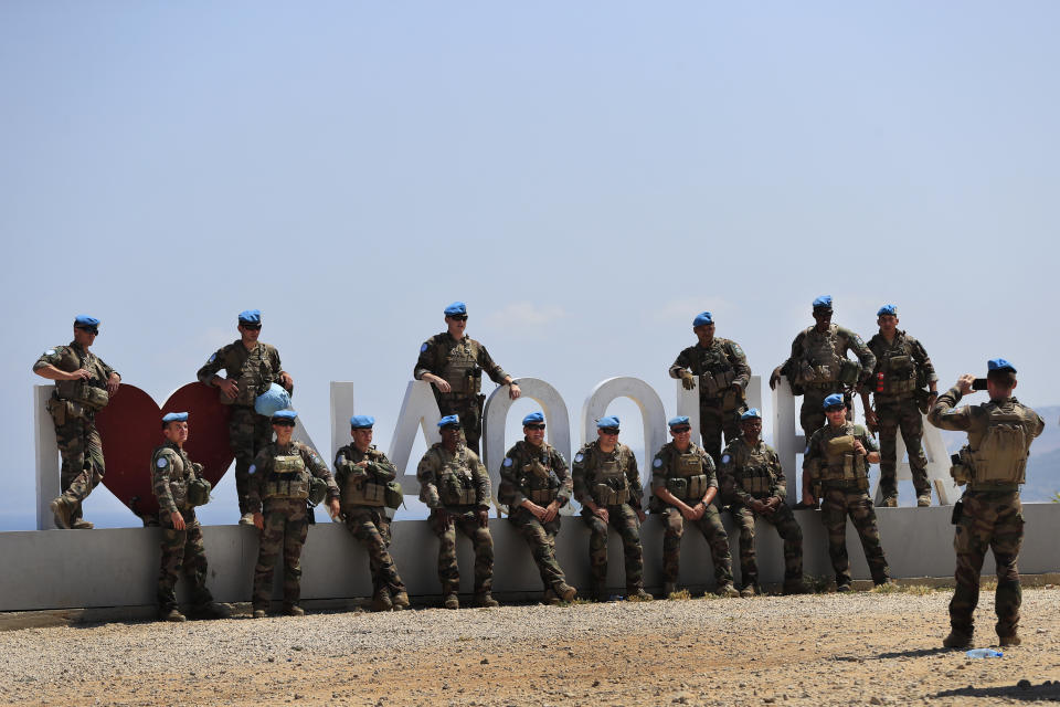 A United Nations Interim Force In Lebanon (UNIFIL) peacekeeper soldier takes pictures of his comrades, along the Lebanese-Israeli border near the town of Naqoura, Lebanon, Monday, June 6, 2022. The Lebanese government invited on Monday a U.S. envoy mediating between Lebanon and Israel over their disputed maritime border to return to Beirut as soon as possible to work out an agreement amid rising tensions along the border. (AP Photo/Mohammed Zaatari)