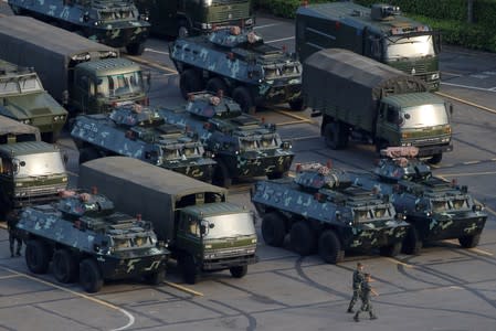 FILE PHOTO: Military vehicles are parked on the grounds of the Shenzhen Bay Sports Center in Shenzhen