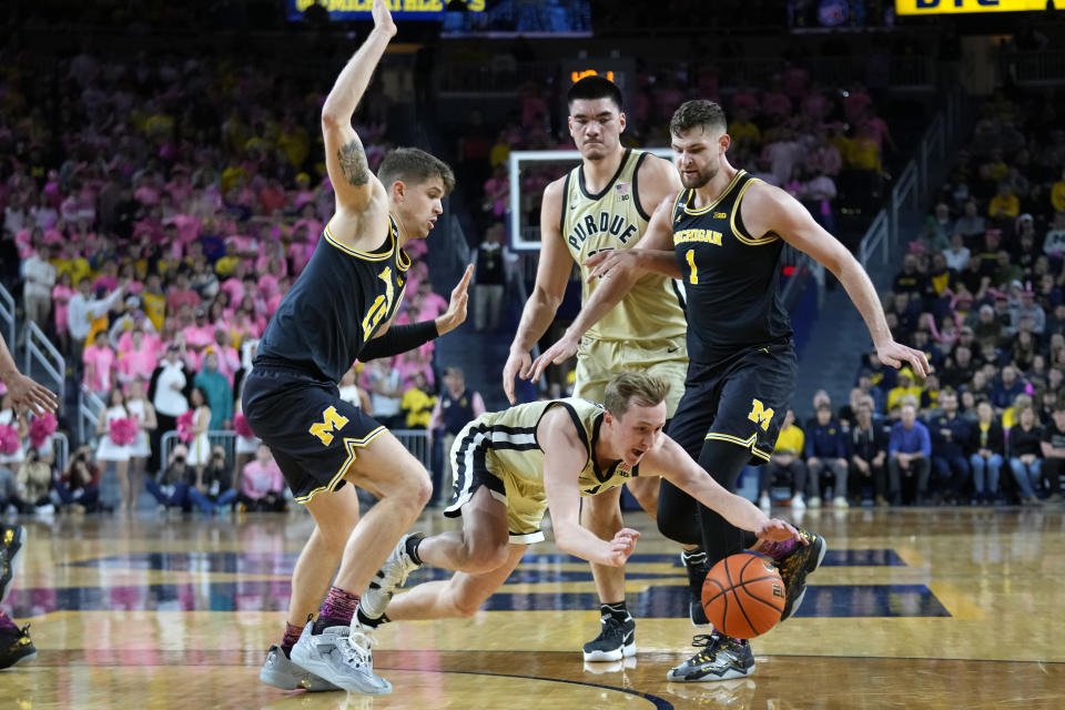 Purdue guard Fletcher Loyer, center, fights for a loose ball with Michigan guard Joey Baker (15) and center Hunter Dickinson (1) during the first half of an NCAA college basketball game in Ann Arbor, Mich., Thursday, Jan. 26, 2023. (AP Photo/Paul Sancya)