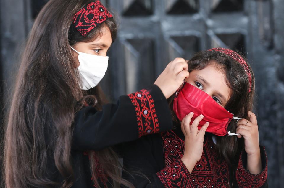 Palestinian girls wearing protective masks attend a graduation ceremony from the Police Academy amid concerns about the spread of the coronavirus COVID-19 in Gaza City on May 7, 2020. (Photo by MAHMUD HAMS / AFP) (Photo by MAHMUD HAMS/AFP via Getty Images)