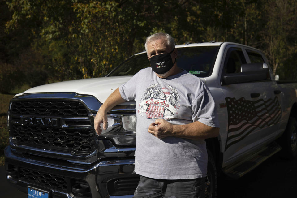 Anthony Starkey, a retired coal miner, stands beside his truck in Danville, W.Va., on Tuesday, Oct. 13, 2020. Starkey said President Donald Trump earned his vote again by signing a bill last year to save the pensions of some retired coal workers, including his own. (AP Photo/Chris Jackson)