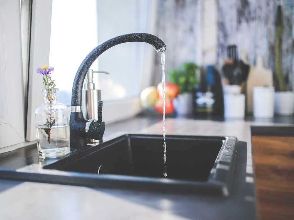 A water faucet slowly pouring water.