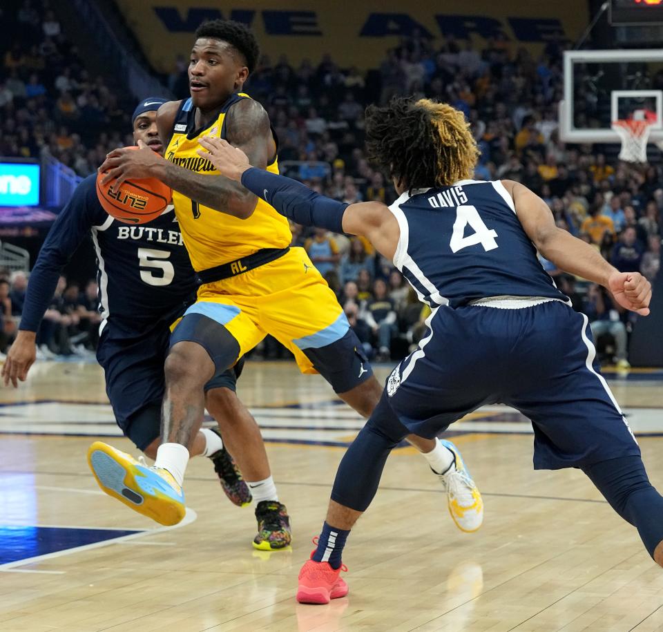 Marquette guard Kam Jones (1) drives between Butler guard Posh Alexander (5) ad guard DJ Davis (4) during a game Jan. 10 at Fiserv Forum in Milwaukee. The two teams will face each other Tuesday night in Indianapolis.