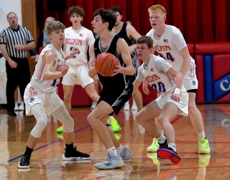 The Caney Valley KS High School Bullpups defense surrounds a Galena player during playoff action against Galena in Caney, KS on Feb. 26, 2024.