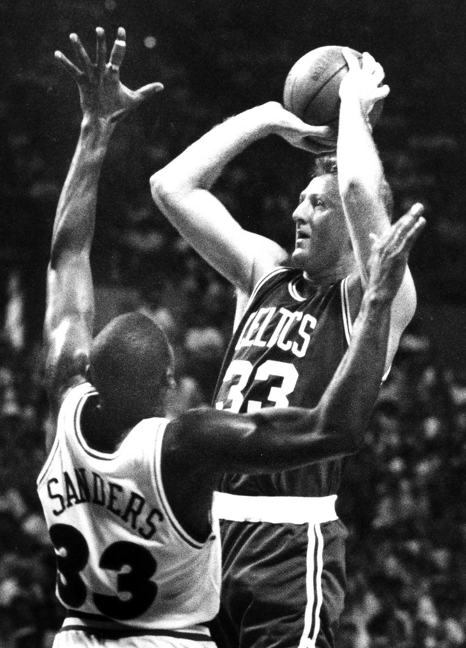 The Boston Celtics' Larry Bird, top, takes a shot over the Cleveland Cavaliers' Mike Sanders at the Richfield Coliseum on May 17, 1992, in Richfield, Ohio.