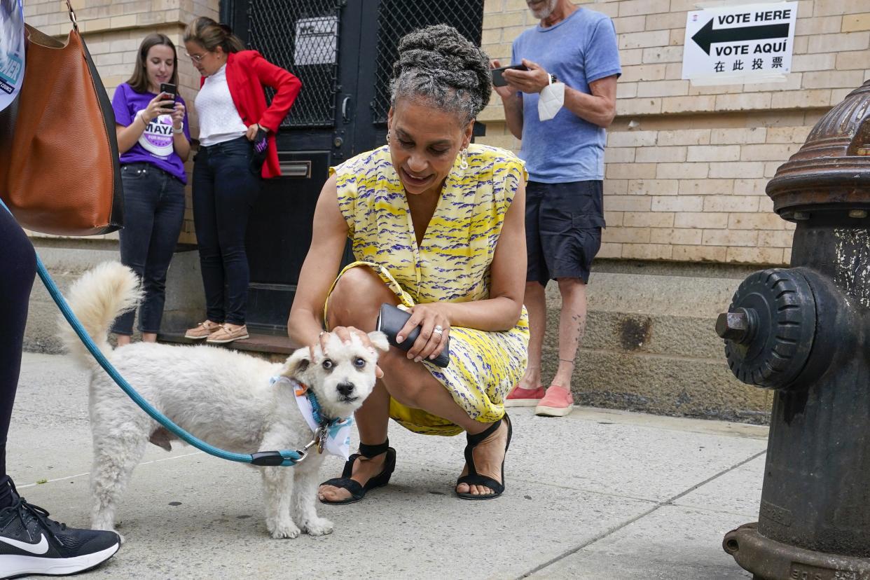 Democratic mayoral candidate Maya Wiley pets a voter's dog during a campaign stop near a polling place in the West Village neighborhood of New York on Tuesday, June 22, 2021.