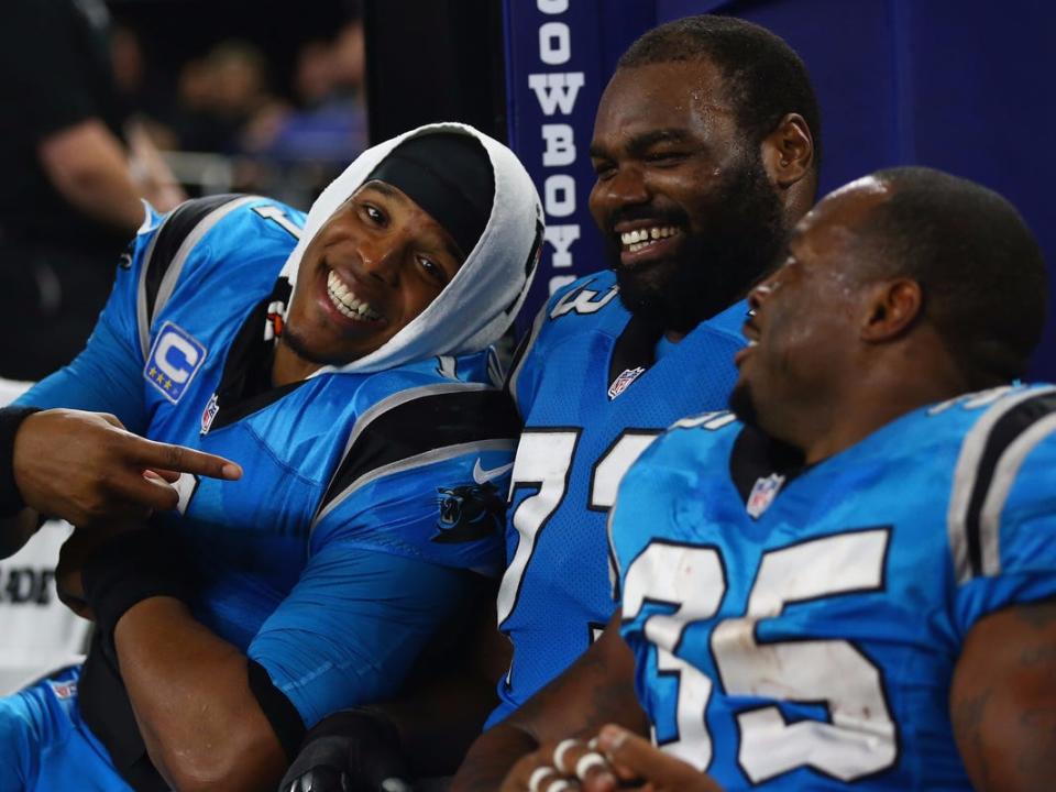 Cam Newton, Michael Oher, and Mike Tomlin smile on Carolina Panthers bench