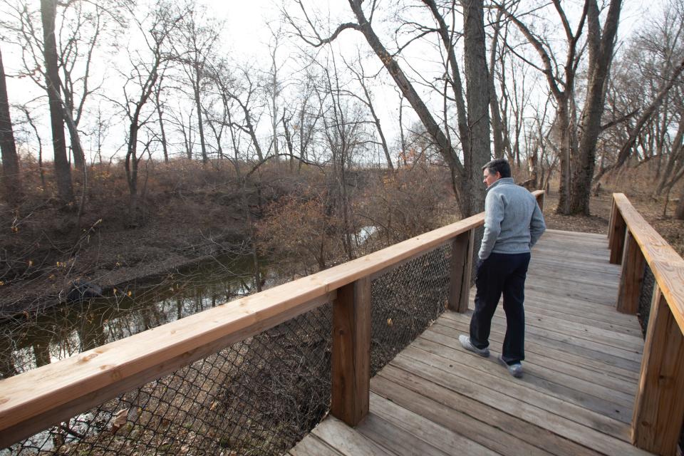 Myron Leinwetter walks across the new bridge spanning a deep ravine on Toadstrangler Trail on Wednesday. Leinwetter says collaboration with private landowners to create public trails on their property is a great benefit to the community.