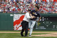 A Texas Rangers security guard tries to tackle a rogue fan who ran onto the playing field in the middle of the 8th inning as the Texas Rangerstake on the Toronto Blue Jays on Opening Day at Rangers Ballpark on April 5, 2010 in Arlington, Texas. The Rangers beat the Blue Jays 5-4. (Photo by Tom Pennington/Getty Images)