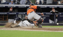 New York Yankees' Didi Gregorius slides past Baltimore Orioles catcher Caleb Joseph to score during the eleventh inning of a baseball game Saturday, Sept. 22, 2018, in New York. The Yankees won 3-2. (AP Photo/Frank Franklin II)